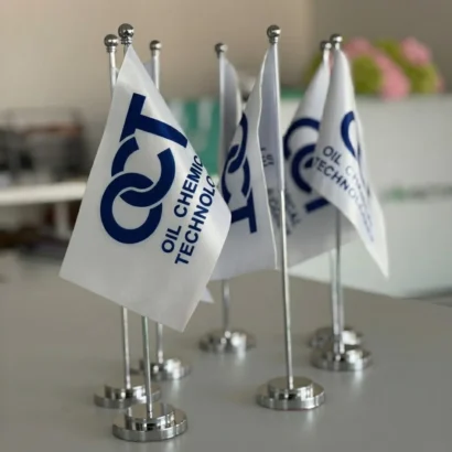 Custom office table flag with polished metal stand studio view for Advertising Point UAE