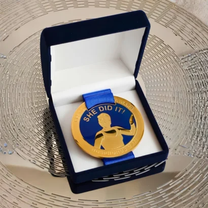 Premium gold championship sport medal with textured athletic relief and custom printed ribbon for UAE tournaments