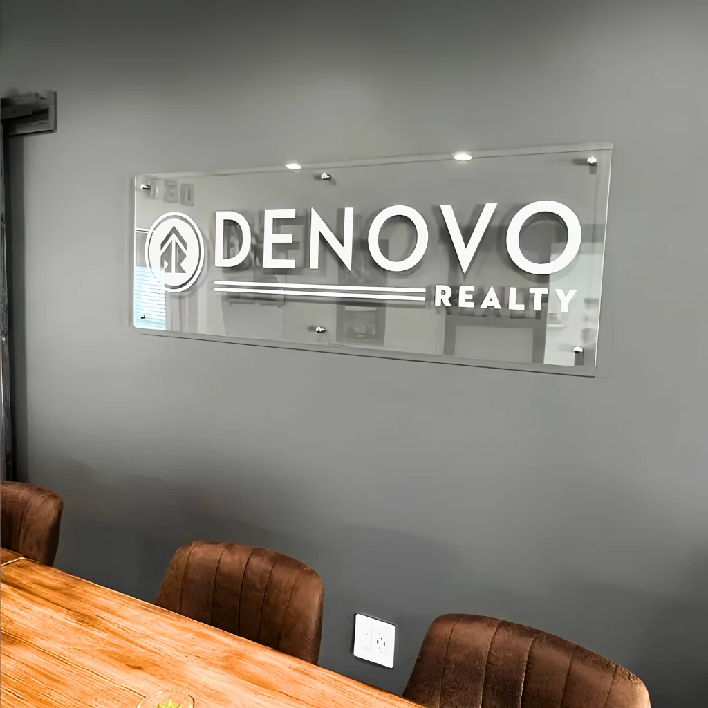 Customized acrylic name plates installed on an office glass partition in Dubai